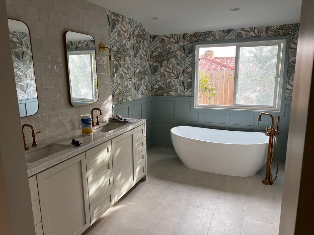 Modern bathroom with freestanding tub, dual mirrors, and elegant wallpaper design.