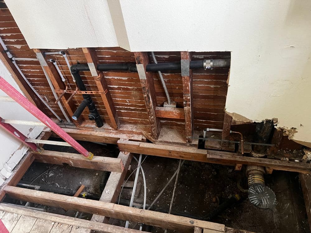 Exposed plumbing and framing in a home renovation project under construction.